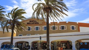 A hotel named "Hostal Bellavista" with a traditional architectural style, featuring a central entrance with arches and a covered outdoor seating area. -  Hostal Bellavista Formentera (Formentera)
