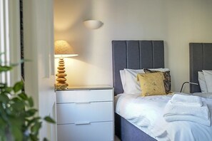 Relax in a stylishly appointed room with a comfortable bed, bedside table, and decorative lamp.