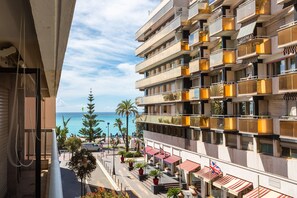 Un hôtel à plusieurs étages, doté de balcons, offrant une vue sur la mer et comprenant des espaces de détente en plein air.