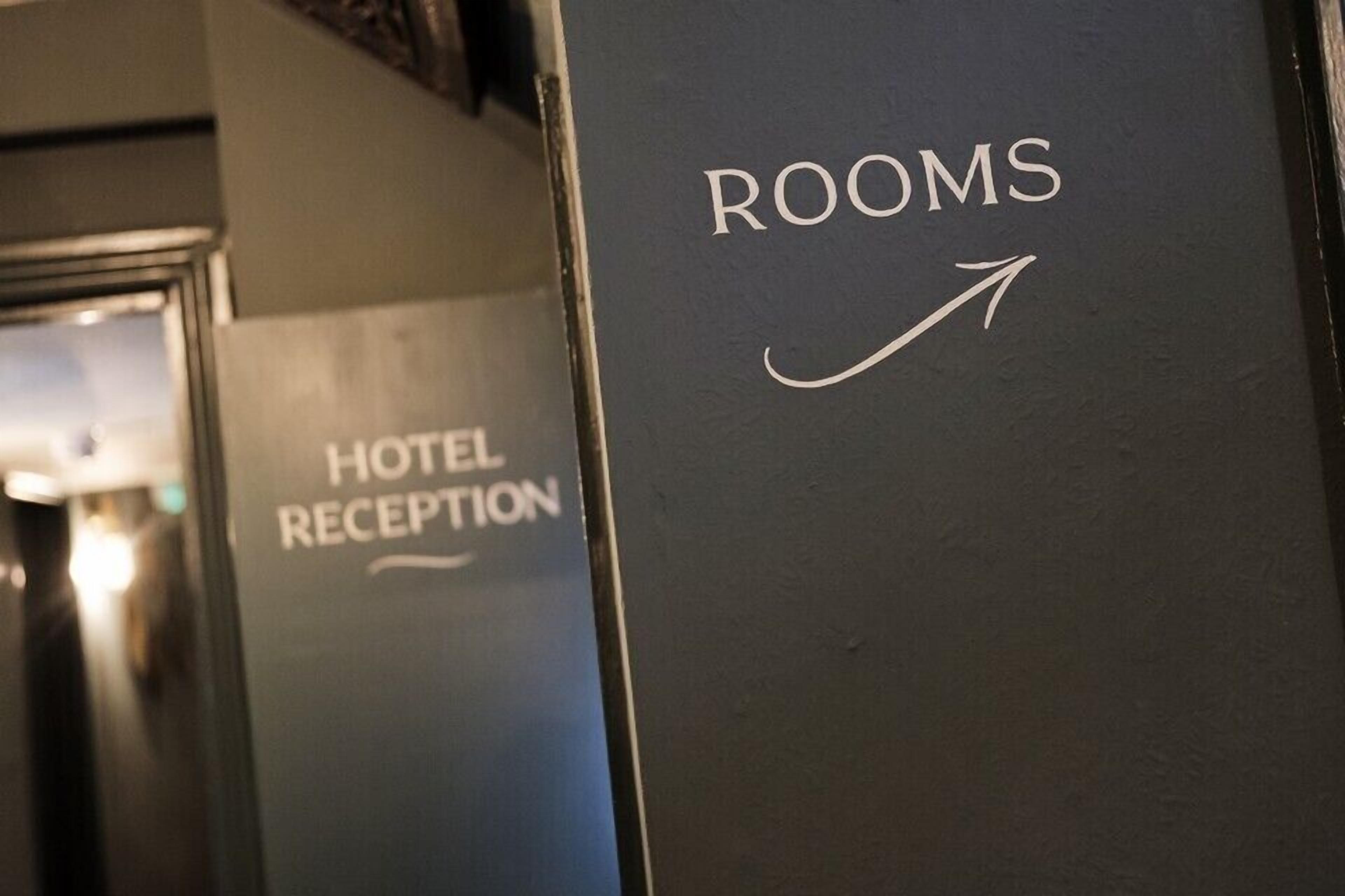 Señal que indica la dirección a las habitaciones del hotel, con una flecha señalando a la derecha.