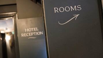 Señal que indica la dirección a las habitaciones del hotel, con una flecha señalando a la derecha.