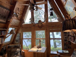 A cozy cabin with a sloped ceiling, wooden walls, and large windows offering views of the outdoors. - ❤️ Beautiful Lake Vermilion Private Island Rental ❤️ (Cook)