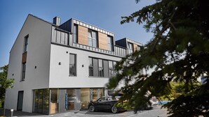 A modern two-story building with large windows and a car parked in front. - Coffee Inn (Kolbudy)