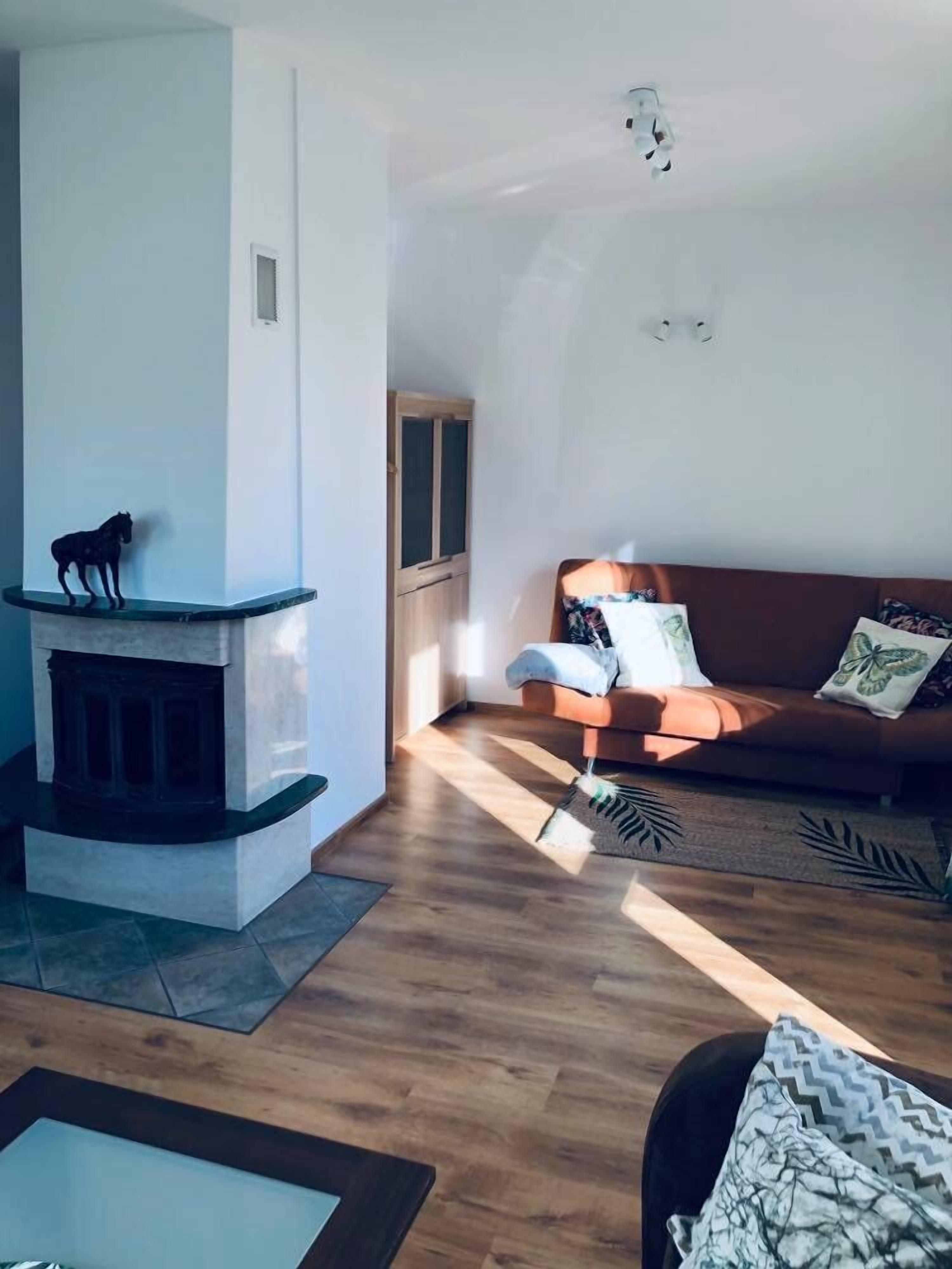 Una sala de estar con chimenea, un sofá y una mesita.