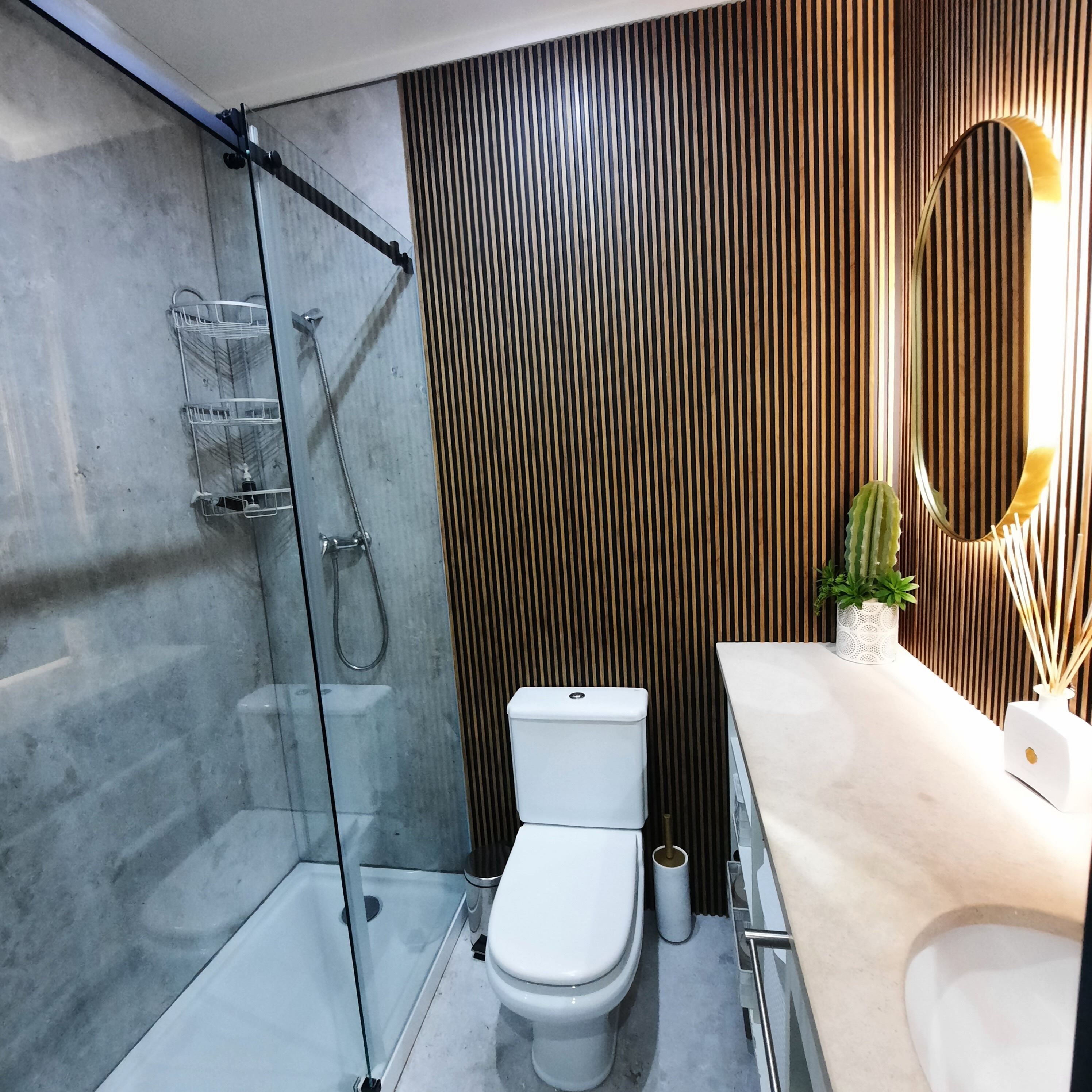 Ein modernes Badezimmer mit Duschkabine aus Glas, Toilette und Waschtisch mit Spiegel.