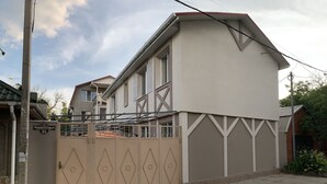Un edificio residenziale con ingresso carrabile, una targa con il numero civico ben visibile e un cielo sereno.