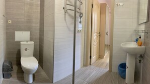 Un bagno moderno con il water, doccia e lavandino.
