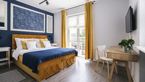 Un dormitorio con cama, escritorio, silla, planta y ventana con cortinas.