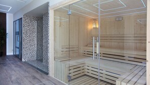 A sauna with glass walls, wooden benches, and a tiled wall. - Helios Benidorm (Benidorm)