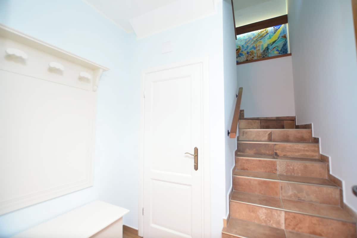 A staircase with beige steps leading to a landing with a white door.