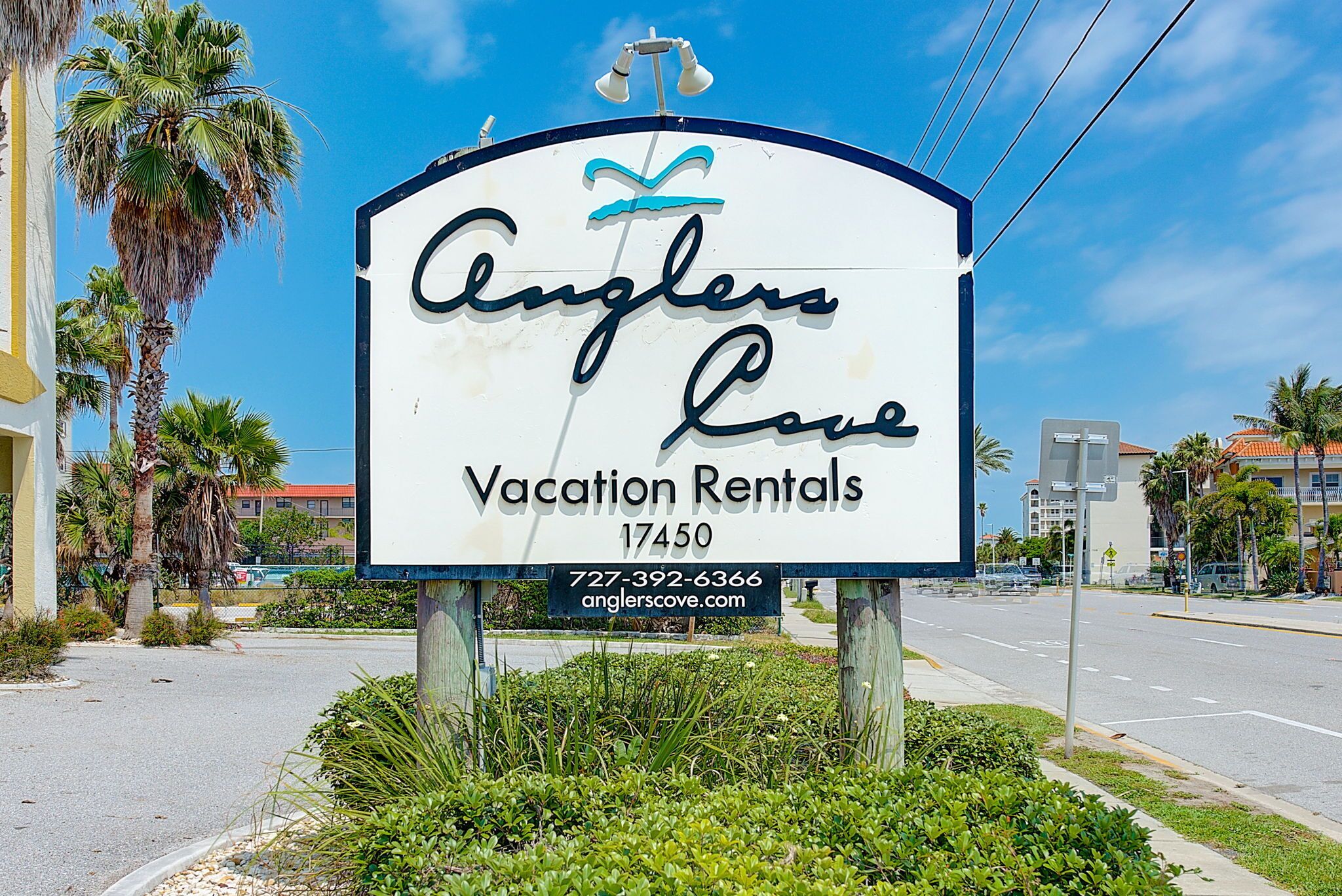 A sign for Anglers Love Vacation Rentals with contact information and a website URL.
