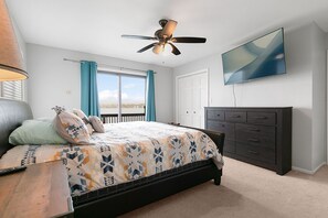 A bedroom with a bed, a ceiling fan, a TV, a dresser, and a window with curtains. - Lake front home on Klinger Lake in Sturgis,  Michigan (Sturgis)