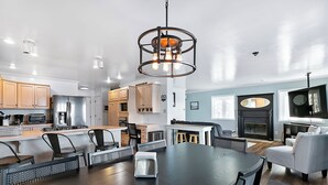 Una cucina moderna con mobili in legno, un'isola centrale e un'area pranzo con tavolo e sedie in legno scuro.