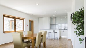 Une cuisine moderne avec des meubles blancs et un plan de travail en bois.