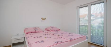 Una camera da letto con un letto, un comodino, una lampada a parete e una porta scorrevole in vetro.