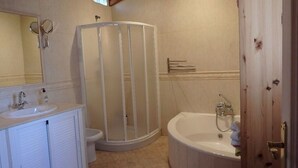 Ein Badezimmer mit Duschkabine, Badewanne und Waschbecken.