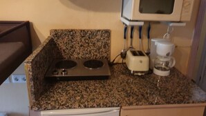 Eine kompakte Küchenzeile mit Mikrowelle, Toaster und Wasserkocher.