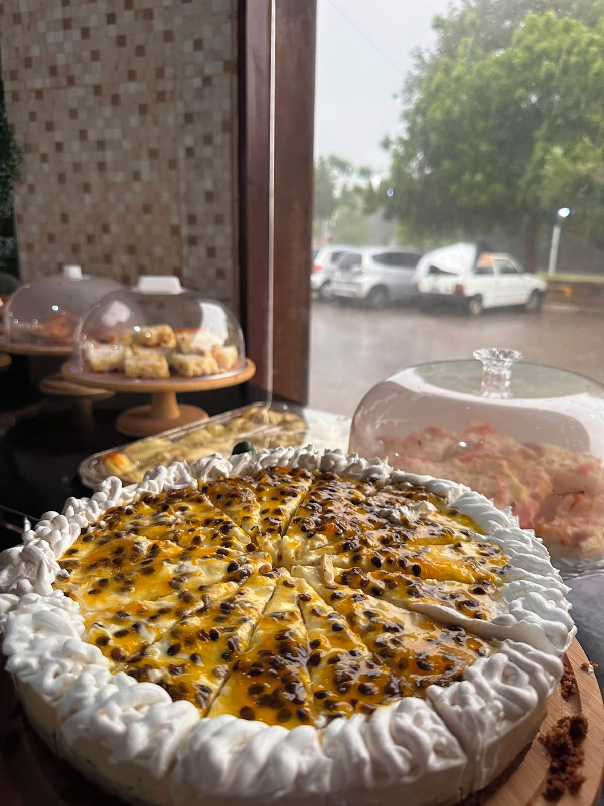 A dessert display with a pie and other pastries in a cafe setting.