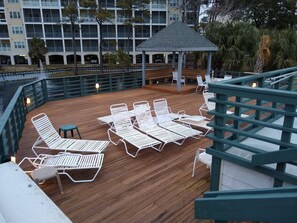 A wooden deck with white lounge chairs and a gazebo. - Excellent rate and Location. (North Myrtle Beach)