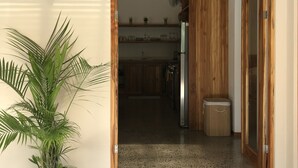A doorway leading to a kitchen with wooden cabinets and a stainless steel refrigerator.