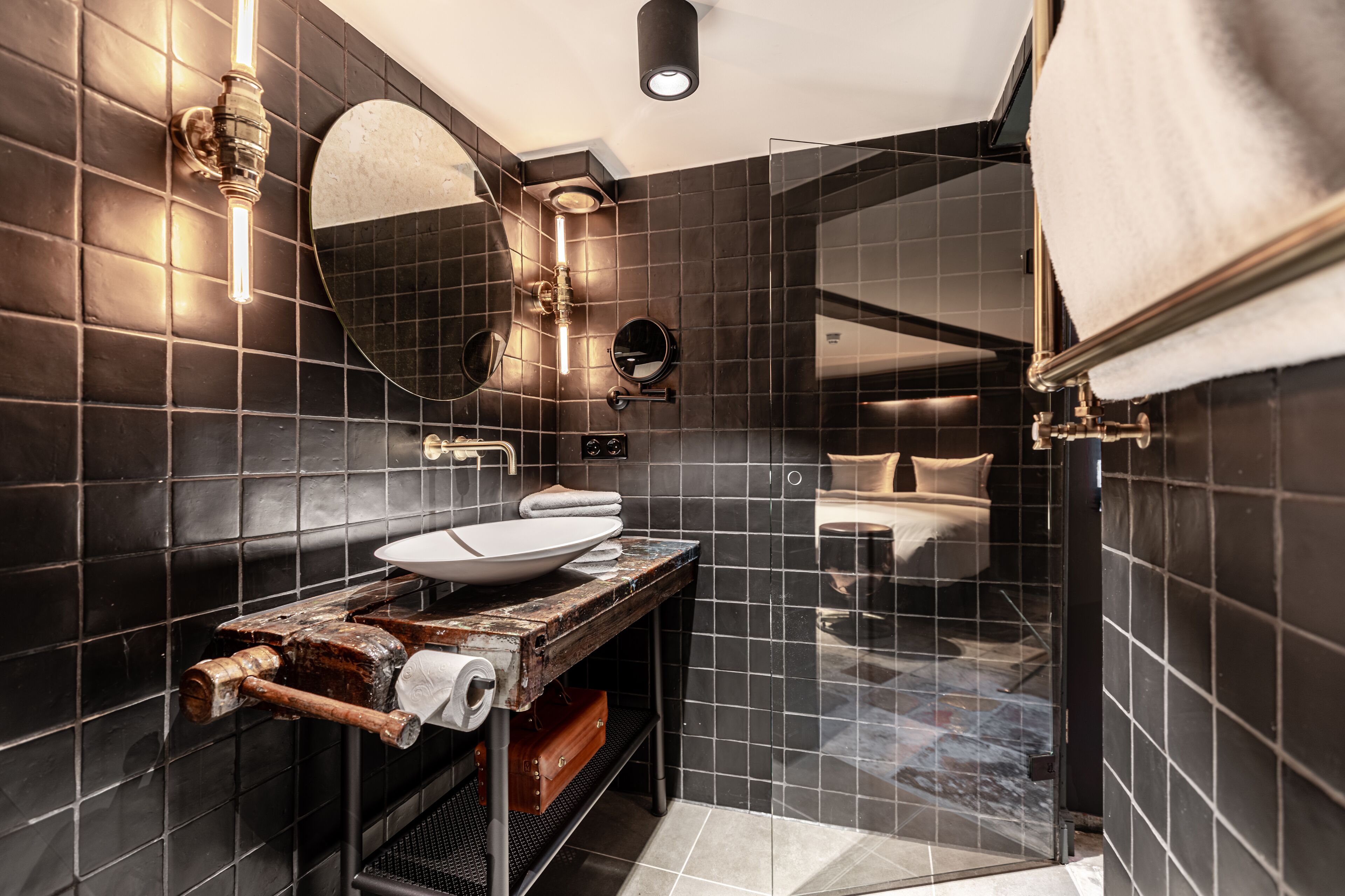 A modern bathroom with a large mirror, a vessel sink, and a shower enclosure.