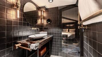 A modern bathroom with a large mirror, a vessel sink, and a shower enclosure.