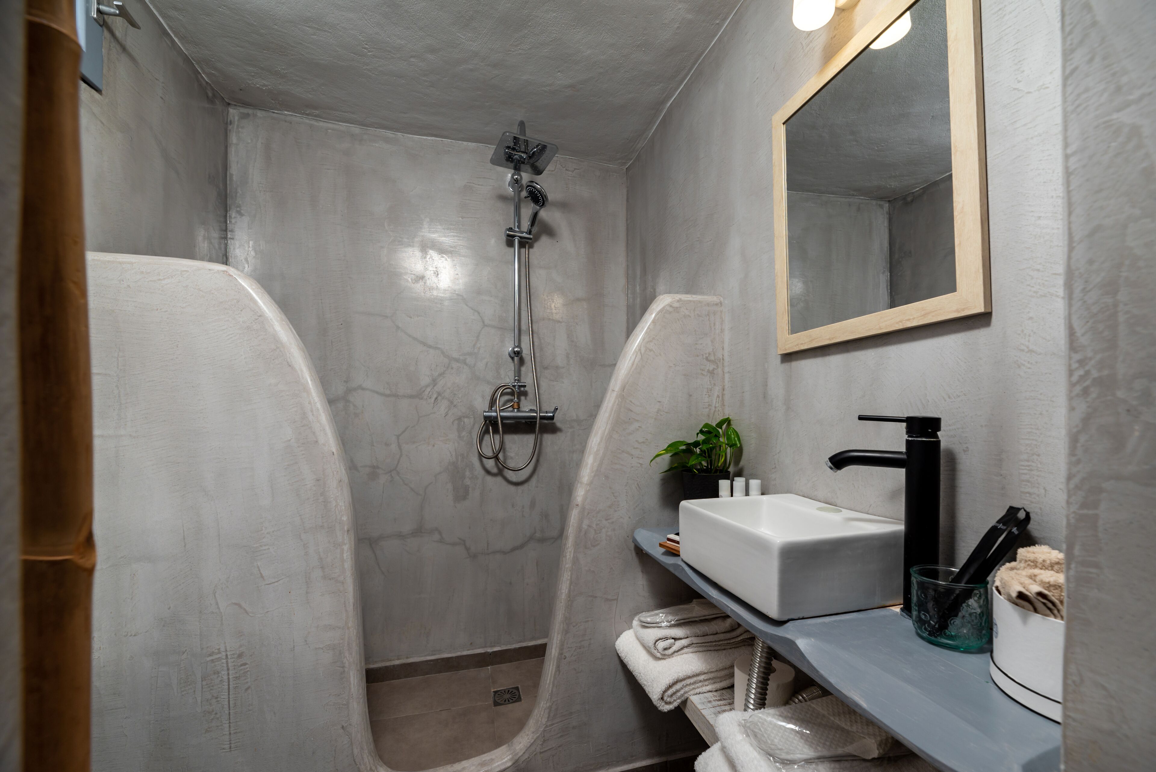 Un baño moderno con ducha, lavamanos y espejo.