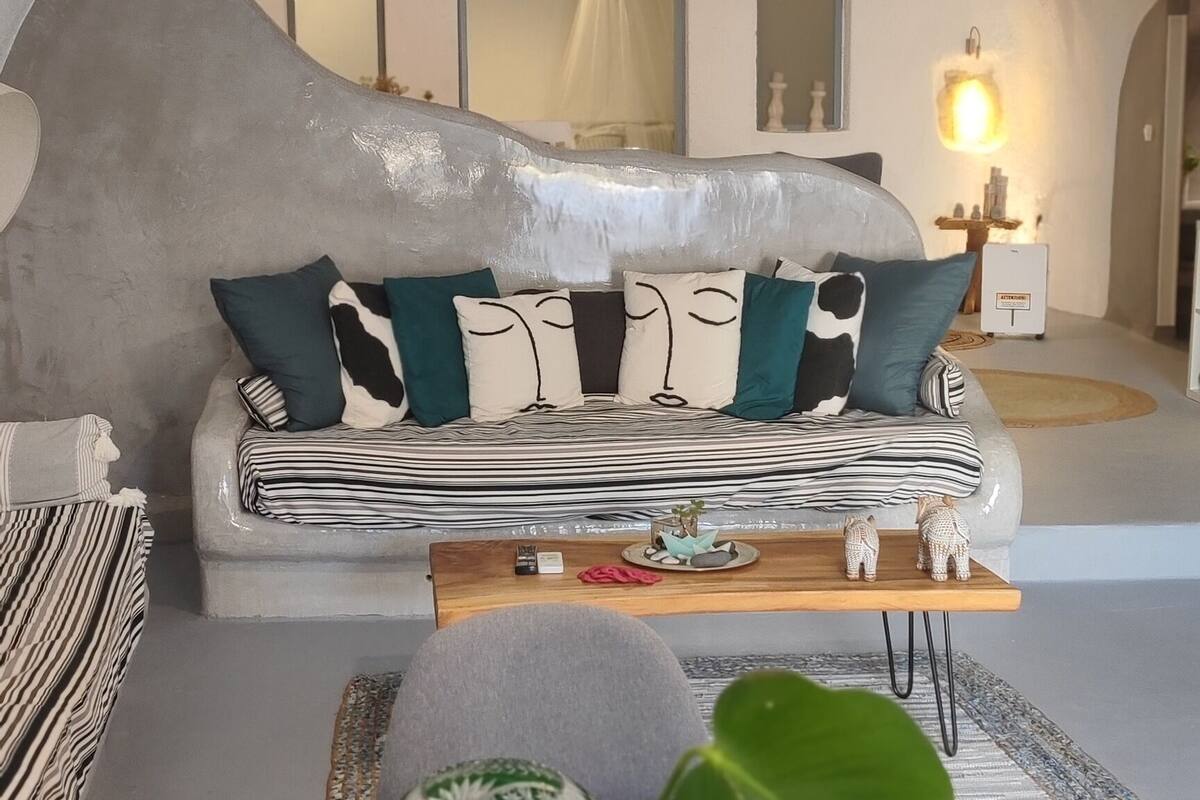 Ein gemütliches Wohnzimmer mit Sofa, Couchtisch und einer Pendelleuchte.