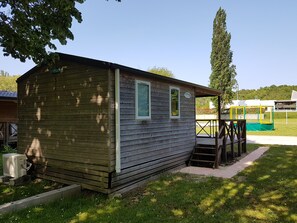 A small wooden cabin with a porch, a window, and a sign that reads "O'Hara." - Camping l'Agrion bleu - Mobil-home (Saint-Martial-de-Valette)