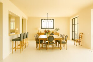 A dining area with a large table surrounded by chairs, a window with a view, and a chandelier. - Grande et belle villa provençale entre Uzès, Nîmes et Avignon « dogfriendly » (Cabrières)