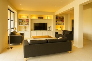 Una Smart TV, libros, una pantalla de ordenador, una impresora