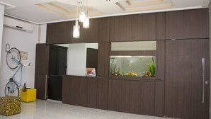 A modern kitchen with dark wood cabinets, a large fish tank, a bicycle, and a yellow box. - Palmas Hostel (Palmas)