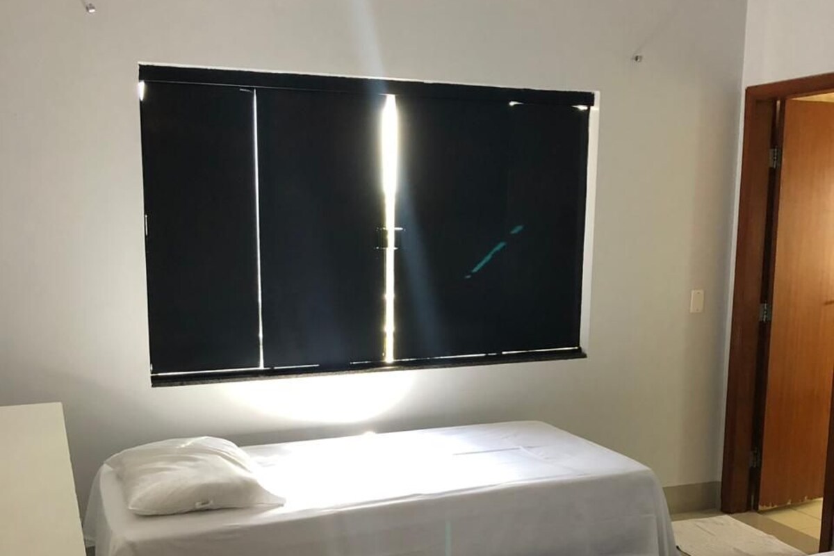 A room with two beds, a large window, and a door.