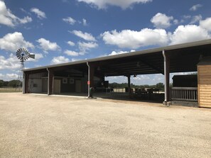 A covered outdoor area with a windmill, tables, and chairs, likely a picnic or event space. - Your next, beautiful getaway! (Hunt)