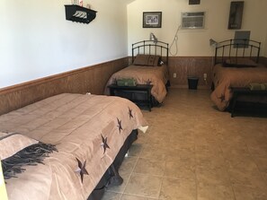 A hotel room with two single beds, a nightstand, a lamp, and a picture on the wall. - Your next, beautiful getaway! (Hunt)