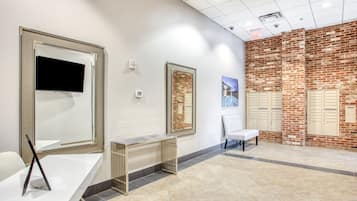 Un área de espera moderna con mostrador de recepción, asientos y una pared de ladrillo.