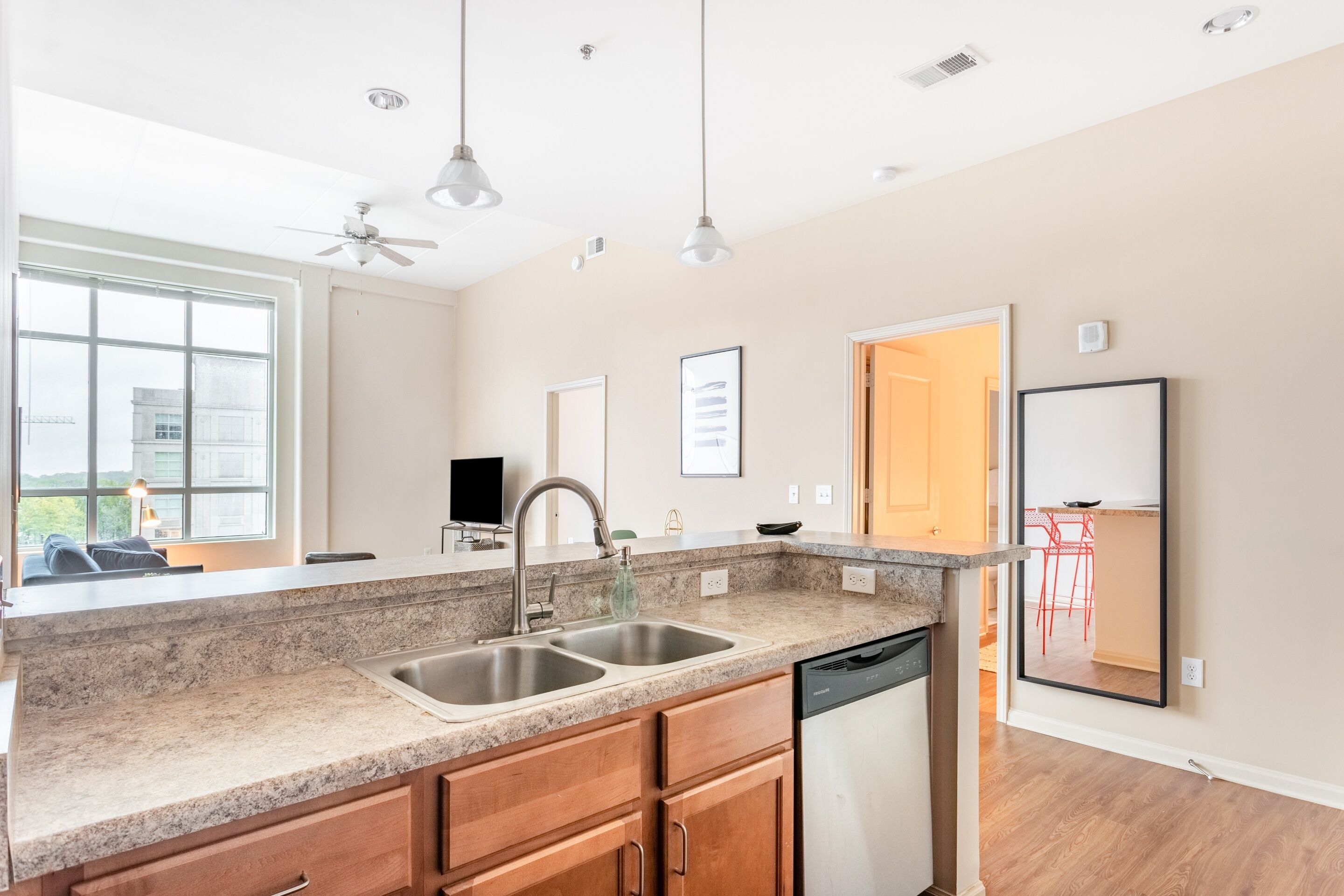 A modern kitchen with granite countertops, a double sink, and a dishwasher.