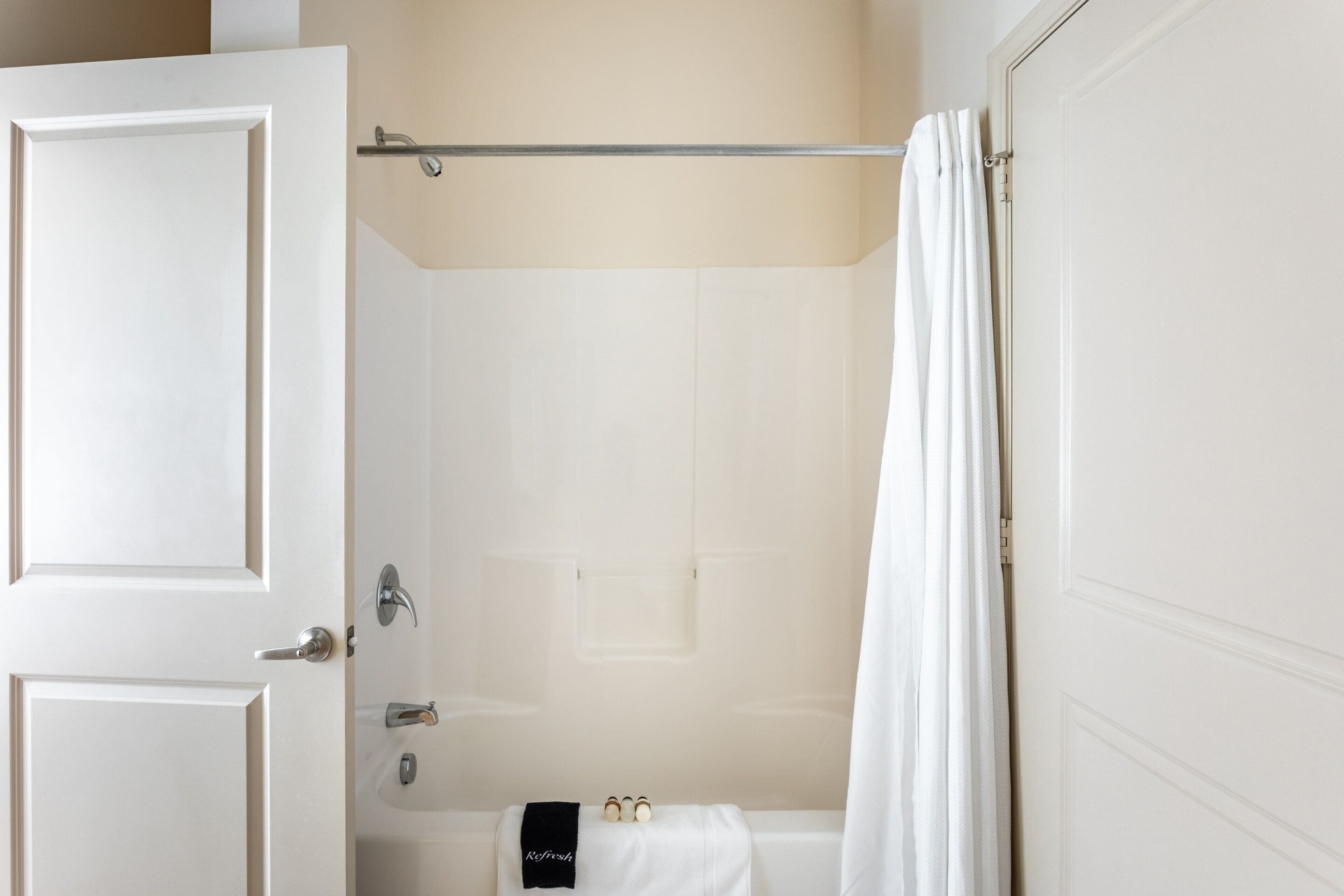Un baño con una bañera, un perchero para toallas y una puerta.
