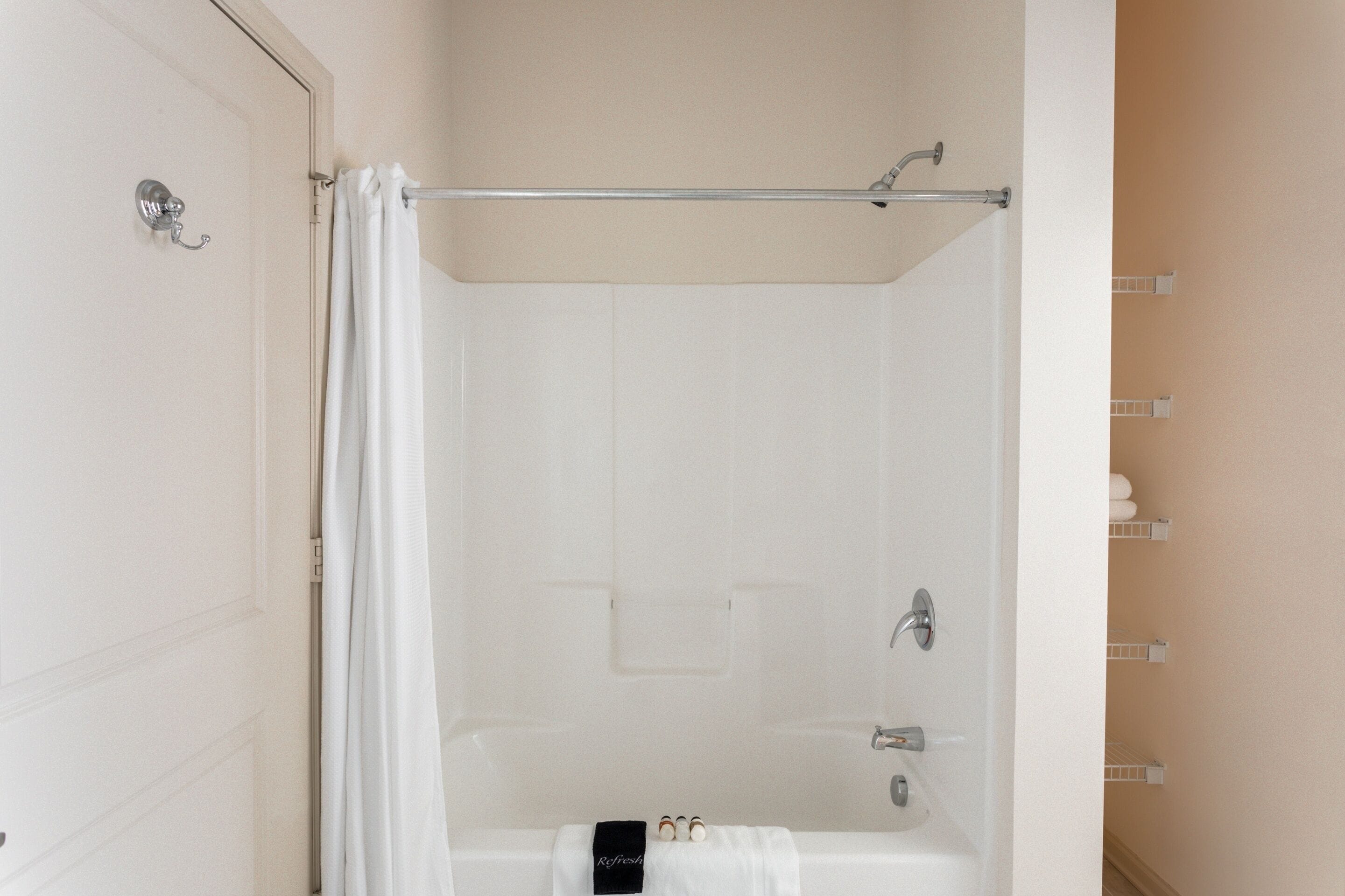 Ein Badezimmer mit einer Badewanne, einer Duschvorhang und einem Handtuchhalter.