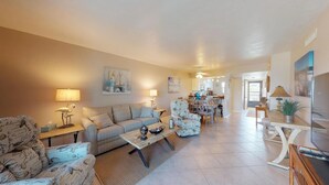 A spacious living room with a sofa, armchairs, and a coffee table. There is a dining area with chairs and a table in the background. - Desirable Location, Directly Across Street From South Beach Access!!! (Marco Island)