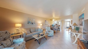 A spacious living room with a sofa, armchairs, and a coffee table. There is a dining area with chairs and a table in the background. - Desirable Location, Directly Across Street From South Beach Access!!! (Marco Island)