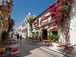 Una calle con mesas al aire libre, un restaurante llamado "Bistro Casani's", y un edificio con un letrero que dice "Hotel Casani's".