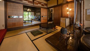 A traditional Japanese room with tatami flooring, a low table, and sliding doors.