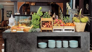 Una exhibición de frutas con plátanos, manzanas y naranjas.