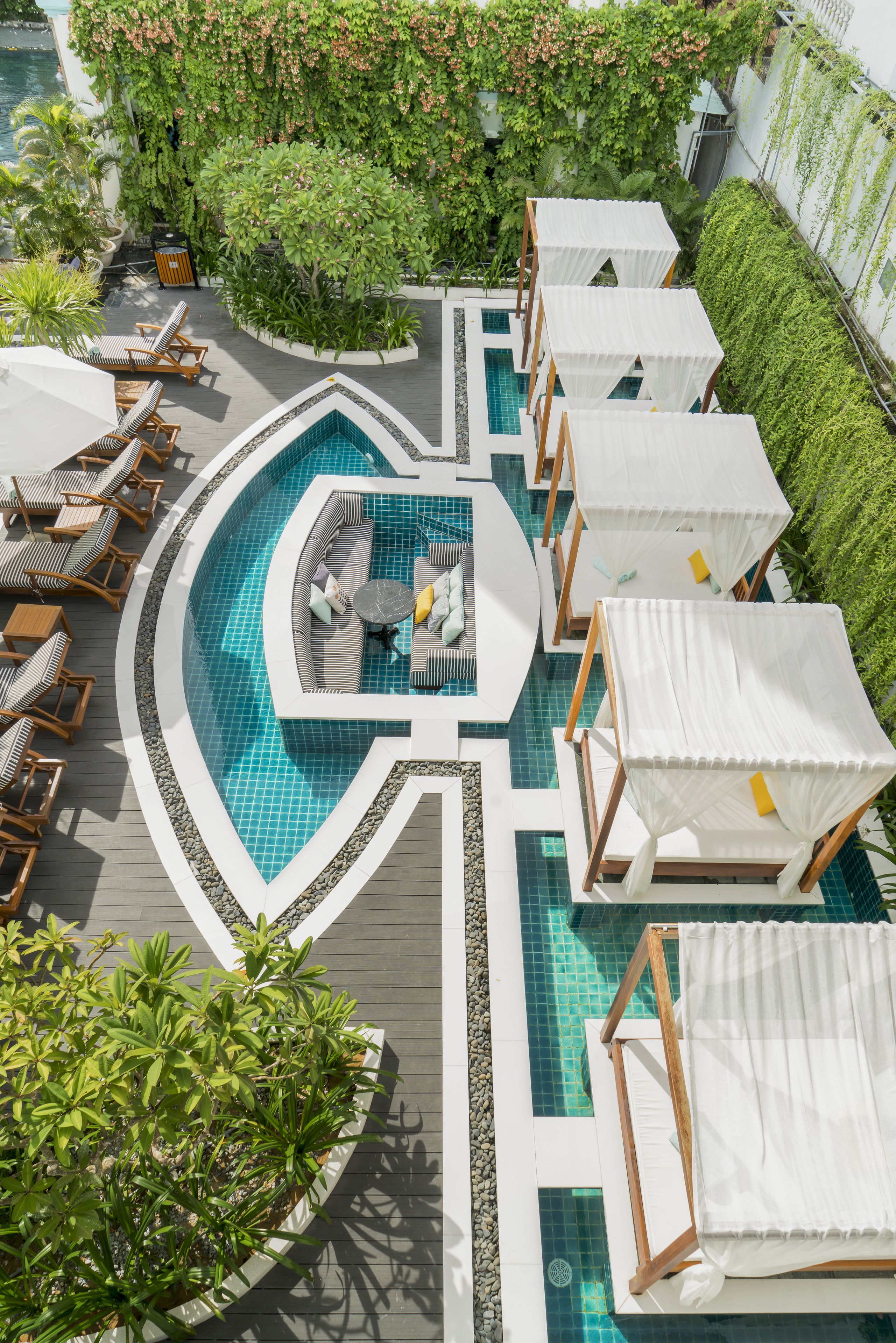 A rooftop pool area with lounge chairs, a seating area, and a small pool.
