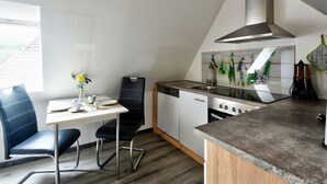A compact kitchen with a dining area, a built-in stove, and a window providing natural light.