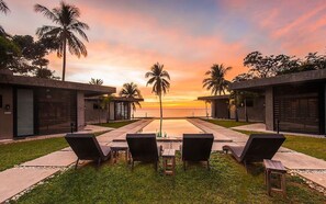A resort with a pool, lounge chairs, and palm trees. - Veue Beach Cabins (Bolinao)