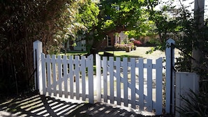 A white picket fence with a stone pillar on the right. - House ALL COMFORT, NICE GARDEN, FEET IN THE WATER, DIRECT BEACH ACCESS (La Hague)