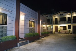A multi-story residential building with a driveway leading to a gated entrance. - Yoo C Apartment (Dumaguete)