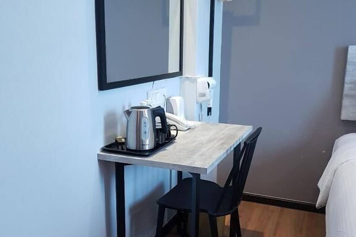 Een bureau, een laptopwerkplek, een strijkplank/strijkijzer